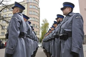 Policjanci z orkiestry i kompani reprezentacyjnej na uroczystościach stojący w dwuszerego