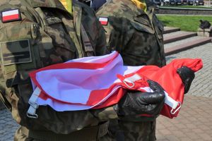 zbliżenie na flagę polski, którą trzymają flagowi