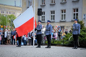 Policyjny poczet flagowy wiesza na maszcie flagę Polski.