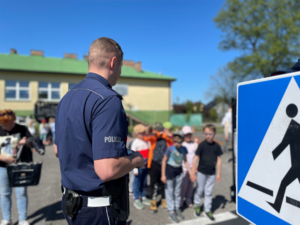 policjant ruchu drogowego na miasteczku rowerowym z dziećmi szkoły podstawowej