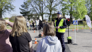 policjant ruchu drogowego w rozmowie z dziećmi na miasteczku rowerowym