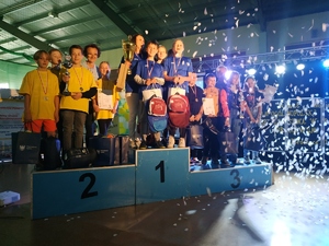 Na zdjęciu widać uczniów grupy młodszej którzy zdobyli odpowiednio pierwsze, drugie oraz trzecie miejsce. Uczniowe stoją na podium.