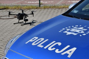 Widok na policyjny dron znad maski radiowozu.