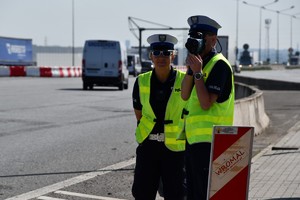 Policjanci z ruchu drogowego mierzą prędkość ręcznymi radarami.