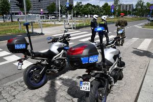 Policyjni motocykliści i żandarm wojskowy kierujący ruchem na skrzyżowaniu