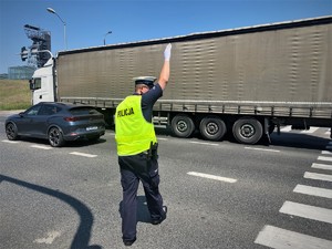 policjant z ruchu drogowego na jezdni kieruje ruchem
