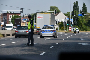 zdjęcie kolorowe; policjant katowickiej drogówki podczas zabezpieczenia wyścigu kolarskiego