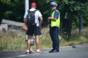 zdjęcie kolorowe: policjant drogówki rozmawiający z pieszymi