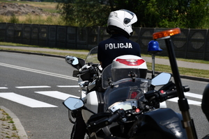 zdjęcie kolorowe: policjant drogówki na motocyklu służbowym