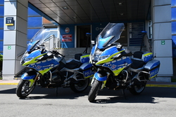 dwa policyjne motocykle ustawione przed wejściem do komendy wojewódzkiej policji