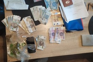 Widoczne zabezpieczone narkotyki, pieniądze i dokumenty