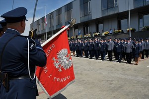 Sztandar Śląskiej Policji, w tle policjanci stojący w pododdziałach.