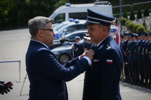 Wojewoda przypina medal Komendantowi Bednarkowi.