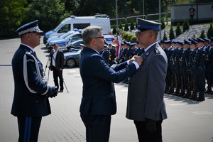 Wojewoda przypina medal policjantowi.