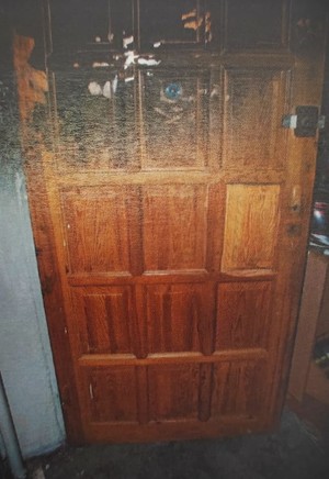 Zdjęcie przedstawia okopcone drzwi.