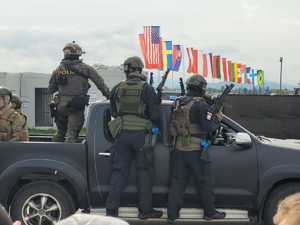 zdjęcie przedstawiające policyjnych kontrterrorystów, stojących na progach samochodu w trakcie działań