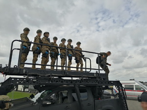 zdjęcie przedstawiające policyjnych kontrterrorystów,  w trakcie działań, stojacych na specjalnym pojeździe z rampą