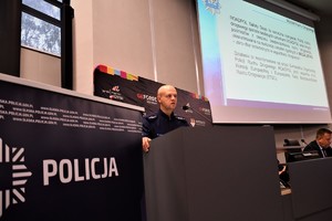 zdjęcie przedstawia policjanta przemawiającego z mównicy