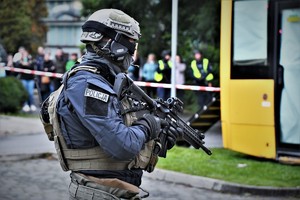 Zdjęcie. Widoczny umundurowany policjant z bronią maszynową