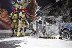 Strażacy gaszący samochód