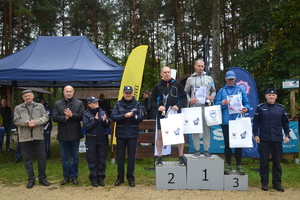 Zdjęcie. Widoczne wręczanie medali i gratulacji uczestnikom po ukończeniu biegu