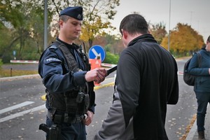 Zdjęcie. osoby i policjanci na terenie zewnętrznym Komendy Wojewódzkiej Policji w Katowicach