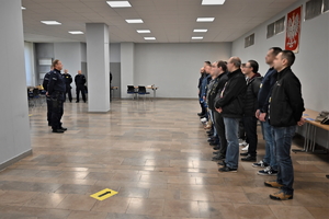 Zdjęcie. Osoby- uczestnicy ćwiczeń, a także umundurowani policjanci i inne osoby prowadzące ćwiczenia na sali