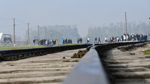 zbliżenie na tory kolejowe. w tle grupa osób zwiedzających