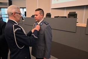 Zdjęcie przedstawia policjanta w trakcie odznaczenia go medalem przez Komendanta