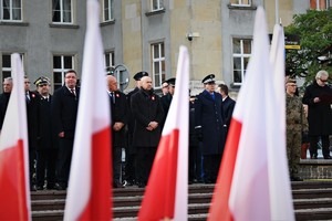 Komendant Wojewódzki Policji wraz z innymi gośćmi na tle flag