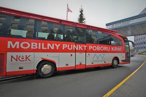Zdjęcie. Autokar RCKiK parkuje przed budynkiem KWP Katowice