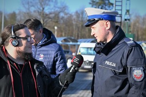 Na zdjęciu dziennikarz rozmawia z policjantem.