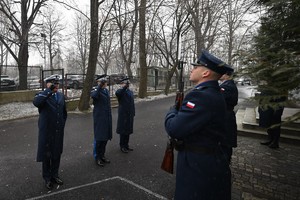Zdjęcie przedstawia policjantów oddających honor przed tablicą pamiątkową