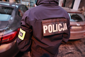 zdjęcie przedstawia zbliżenie na napis POLICJA na kurtce policjanta