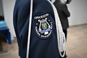 zdjęcie przedstawia zbliżenie na naszywkę na mundurze policjanta z orkiestry policyjnej