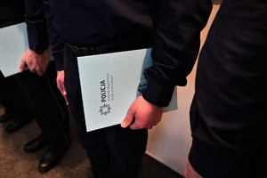 zdjęcie zbliżenie na trzymaną w ręce przez policjanta teczkę