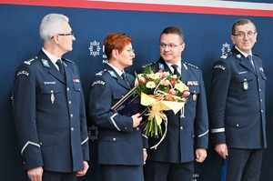 Rzecznik z kwiatami stojąca obok Rzecznika KGP. Po bokach Komendant Wojewódzki i jego Zastępca