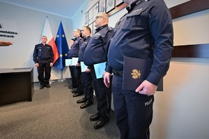 Zdjęcie przedstawia stojących w szeregu policjantów.