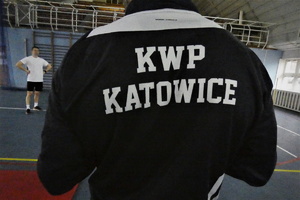 Zdjęcie przedstawia zbliżenie na napis KWP Katowice na plecach instruktora.