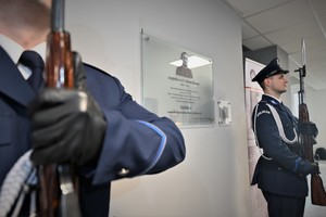 Zdjęcie. Widoczni umundurowani policjanci stojący w korytarzu