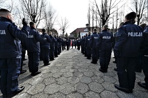 zdjęcie przedstawia stojących policjantów w trakcie ślubowania, w tle widoczny sztandar