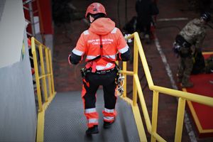 Zdjęcie przedstawia ratownika górniczego schodzącego po schodach
