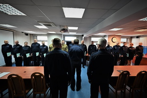 zdjęcie przedstawia policjantów stojących w szeregu w trakcie uroczystości