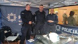 Na zdjęciu mundurowi stojący przy stoisku promującym zawód policjanta