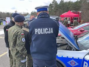 Na zdjęciu policjant z drogówki prezentuje radiowóz uczestnikom XI Ogólnopolskiego Turnieju Klas Mundurowych.