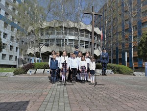 Zdjęcie. Widoczni uczniowie szkoły podstawowej przed grobem policjanta polskiego na terenie KWP w Katowicach