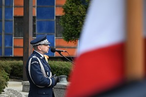 Zdjęcie. Głos podczas uroczystości na terenie KWP w Katowicach zawiera jej uczestnik