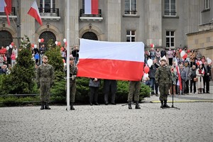Zdjęcie. Moment podniesienia flagi państwowej na Placu Sejmu Śląskiego. Widoczni również uczestnicy uroczystości