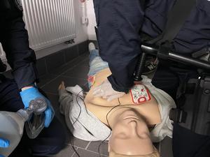 zdjęcie przedstawia zbliżenie na manekina do ćwiczeń masażu serca, na którym ćwiczą policjanci.