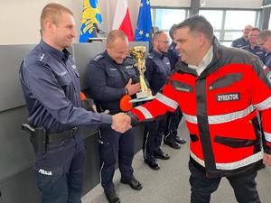 zdjęcie przedstawia ratownika medycznego wręczającego policjantom nagrody.